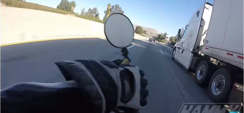 Motociclista casi es aplastado por trailer al perder el control de su moto.