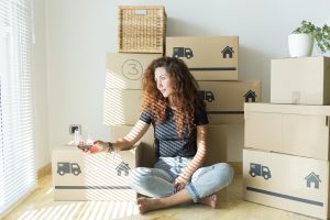 Young woman sitting in new home with glass of red wine