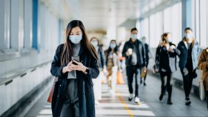 si-se-respeta-la-cuarentena-en-dos-semanas-podria-salir-el-ultimo-infectadok using smartphone while commuting in the urban bridge in city against crowd of people