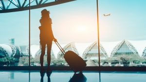 Silhouette Woman With Luggage Standing In Airport